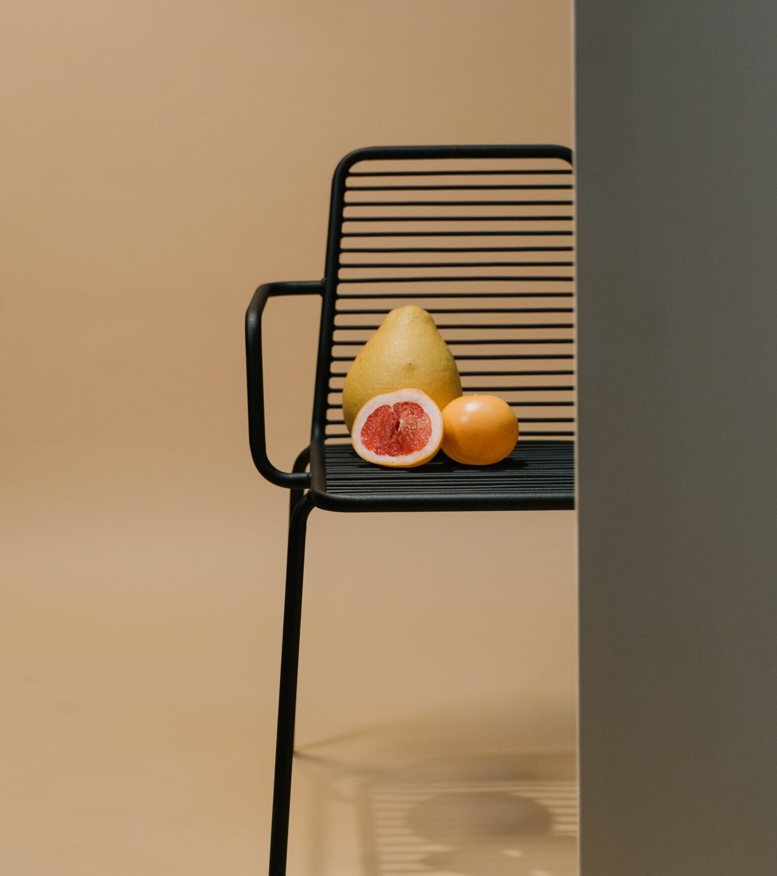 Stolik z owocami na tle neutralnego tła, minimalistyczny design, elegancka aranżacja wnętrza.