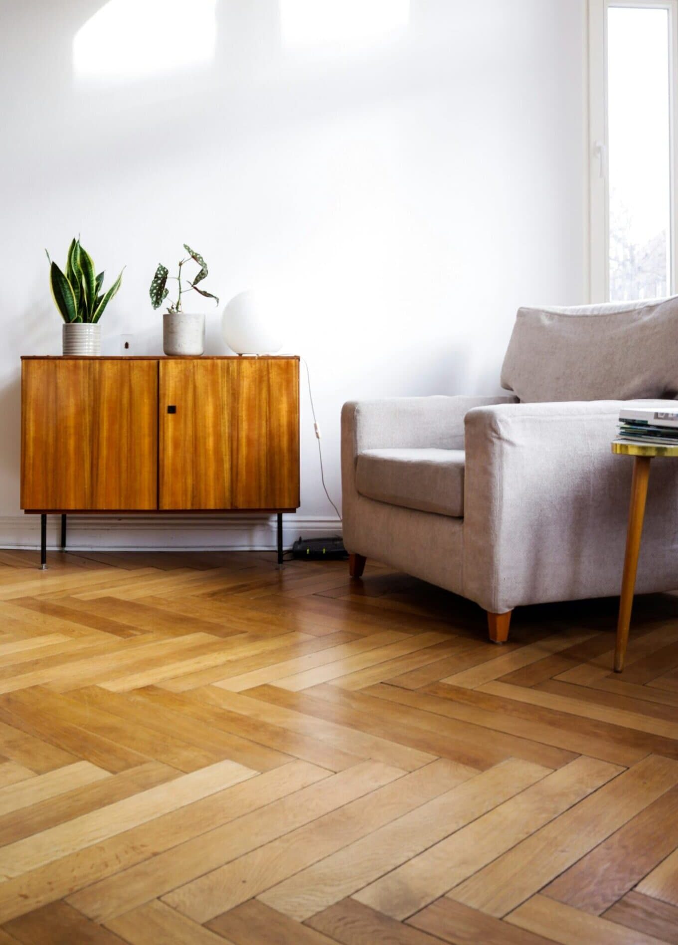 Przestronny salon z naturalnym światłem, białymi ścianami i eleganckim umeblowaniem – portfolio projektanta wnętrz.